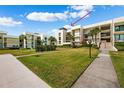 Modern condo building with lush landscaping and a rooftop terrace at 50 Coe Rd # 331, Belleair, FL 33756
