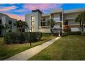 Modern condo building with lush landscaping and walkway at dusk at 50 Coe Rd # 331, Belleair, FL 33756