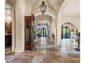 Elegant entryway with high ceilings, arched doorways and antique clock at 7725 Still Lakes Dr, Odessa, FL 33556