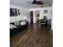 Cozy living room featuring wood-look floors, a ceiling fan, comfortable seating, and an adjacent dining area at 5347 81St N Ln # 22, St Petersburg, FL 33709