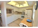Bright kitchen with white cabinets, tile backsplash, and a breakfast nook at 948 Virginia St # 205, Dunedin, FL 34698