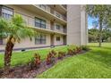 Exterior view of condo building with landscaping and grassy area at 900 Cove Cay Dr # 1H, Clearwater, FL 33760