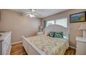 Bright bedroom with white bed, wood floors, and ceiling fan at 900 Cove Cay Dr # 1H, Clearwater, FL 33760