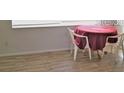Small dining area with table and chairs, featuring light wood flooring at 4102 Darlington Rd, Holiday, FL 34691