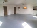 Spacious garage with light grey epoxy floor and two ceiling fans at 4102 Darlington Rd, Holiday, FL 34691
