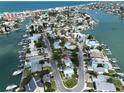Aerial view showcases this waterfront home, surrounded by lush landscaping and serene canals at 13004 Boca Ciega Ave, Madeira Beach, FL 33708
