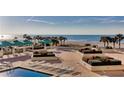 Relaxing pool area with lounge chairs, cabanas, lush landscaping and Gulf of Mexico view at 1380 Gulf Blvd # 1008, Clearwater Beach, FL 33767