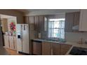 Efficient kitchen featuring wood cabinets, modern appliances, and natural light from the window at 189 Colonial Blvd # 24, Palm Harbor, FL 34684