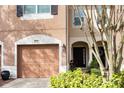 Townhouse exterior with a double garage and manicured landscaping at 2619 Redford Way, Wesley Chapel, FL 33544