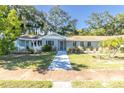 Light blue ranch home with a walkway and landscaping at 5523 Carlton Rd, New Port Richey, FL 34652