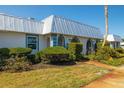 Exterior view of a condo with a metal roof and lush landscaping at 4239 Tamargo Dr, New Port Richey, FL 34652