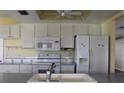 Bright kitchen features white appliances, ample cabinetry, and a double sink at 4251 100Th N Ave # 2, Pinellas Park, FL 33782