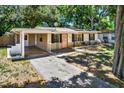 Front view of the house with mature trees at 6490 34Th N Ave, St Petersburg, FL 33710