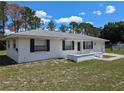 Front view of a ranch-style house with white exterior and black shutters at 4673 Kirkland Ave, Spring Hill, FL 34606