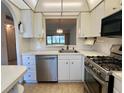 White kitchen with stainless steel appliances and pass-through at 1280 Mission Cir # 45C, Clearwater, FL 33759