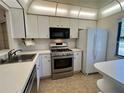 Bright kitchen with white cabinets and stainless steel appliances at 1280 Mission Cir # 45C, Clearwater, FL 33759