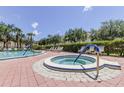 Inviting outdoor pool and spa area with comfortable seating and mature landscaping for a relaxing atmosphere at 129 Brent Cir, Oldsmar, FL 34677