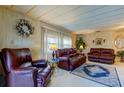 Spacious living room featuring leather reclining furniture and a large area rug at 402 Blue Marlin Dr, Oldsmar, FL 34677