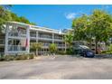 Two-story building with balconies overlooking the parking lot and lush greenery at 2533 Dolly Bay Dr # 306, Palm Harbor, FL 34684