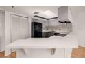 Modern kitchen with dark cabinetry and breakfast bar at 1750 Harbor S Pl # 103, South Pasadena, FL 33707