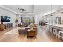 Spacious living room with wood floors, a modern ceiling fan, and large windows for ample light at 16701 Vibrato Ln, Land O Lakes, FL 34638