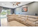 Tan sectional sofa in spacious living room with access to patio at 2985 Jacob Crossing Ln, Holiday, FL 34691