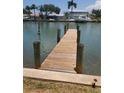 Wooden dock extending into calm water with palm trees in background at 318 Windrush Blvd # 9, Indian Rocks Beach, FL 33785