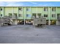 Front view of a light green two-story building with parking underneath at 318 Windrush Blvd # 9, Indian Rocks Beach, FL 33785