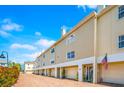 Townhome featuring an attached garage, brick paved driveway, and manicured landscaping at 1109 Pinellas Bayway S # 306, Tierra Verde, FL 33715