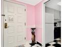 Entryway with white door, pink walls, and a view of the kitchen at 36750 Us Highway 19 N # 03102, Palm Harbor, FL 34684