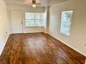 Bright living room featuring wood-look floors and a ceiling fan at 5816 Congress St # 104, New Port Richey, FL 34653