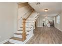 Open-concept living space featuring a staircase, wood-look floors, and access to the kitchen at 49 W Boyer St, Tarpon Springs, FL 34689