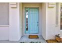 Inviting light teal front door with sidelights and a welcome mat at 10426 48Th E Ct, Parrish, FL 34219