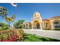 Community clubhouse with landscaping and a flag at 2746 Via Tivoli # 132B, Clearwater, FL 33764
