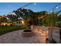 Relaxing backyard patio with fire pit and string lights at 2053 Golf View Dr, Dunedin, FL 34698