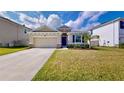 Charming one-story house with two-car garage and landscaped lawn at 30964 Penny Surf Loop, Wesley Chapel, FL 33545