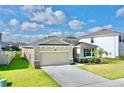 One-story house with stone accents, two-car garage, and lush landscaping at 30964 Penny Surf Loop, Wesley Chapel, FL 33545