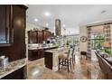 Beautiful kitchen with dark wood cabinetry, granite countertops, a central island, and stainless steel appliances at 620 Ponce De Leon Dr, Tierra Verde, FL 33715