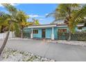 Inviting single-story home with a vibrant blue exterior, well-maintained landscaping, and a spacious driveway at 6465 30Th S St, St Petersburg, FL 33712