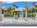 Beautiful blue single-story home featuring a lovely front yard with mature palm trees at 6465 30Th S St, St Petersburg, FL 33712