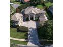 Expansive aerial view of a luxurious home with lush landscaping, a sprawling driveway, and manicured lawns at 667 Richmond Close, Tarpon Springs, FL 34688