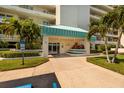 Inviting building entrance with a teal awning, lush landscaping, and easy access for visitors at 7979 Sailboat Key S Blvd # 506, South Pasadena, FL 33707