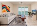 Bright living room featuring tile floors, modern furniture, ceiling fan, and sliding doors to a view of the water at 7979 Sailboat Key S Blvd # 506, South Pasadena, FL 33707