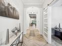 Bright entryway with herringbone floors and modern decor at 4219 Woodland Retreat Blvd, Trinity, FL 34655