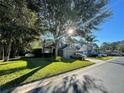 Two-story house on a tree-lined street with a car in the driveway at 13856 Royston Bnd, Hudson, FL 34669