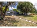 Gray house with blue door and walkway, surrounded by mature trees at 5609 20Th S Ave, Gulfport, FL 33707