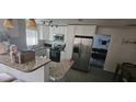 Well-lit kitchen featuring granite countertops, stainless steel refrigerator, modern appliances, and white cabinetry at 2312 22Nd Sw Ave, Largo, FL 33774
