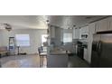 Light and bright kitchen featuring granite countertops, stainless steel refrigerator, modern appliances, and white cabinetry at 2312 22Nd Sw Ave, Largo, FL 33774