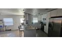 Bright kitchen with an eat-in bar, stainless steel appliances, white cabinets, and a window overlooking the yard at 2312 22Nd Sw Ave, Largo, FL 33774