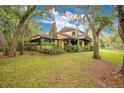 Rustic home with stone fireplace and deck, nestled among lush trees at 16835 Old Moulton Rd, Spring Hill, FL 34610